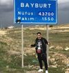 Calhanoglu pozându-se cu un indicator rutier al provinciei Bayburt