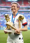 Megan Rapinoe, în 2019, cu trofeele pentru titlul mondial, pentru golgeterul și MVP-ul turneului final Foto: Imago